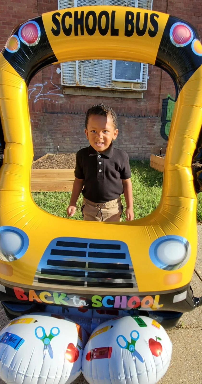 Young child smiling in a school bus play display
